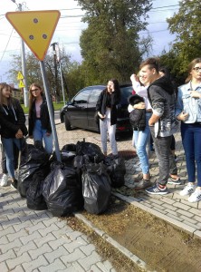 Grupowe zdjęcie przy zebranych workach ze śmieciami