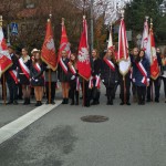 Uczniowie pozujący ze sztandarem oraz flagami polski