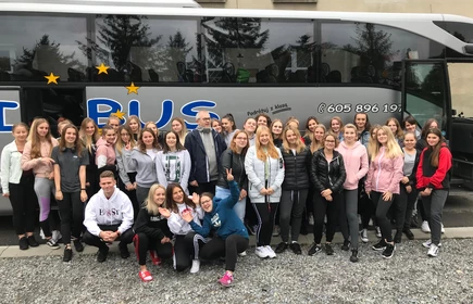 Na zdjęciu grupa uczniów pozująca przed autobusem