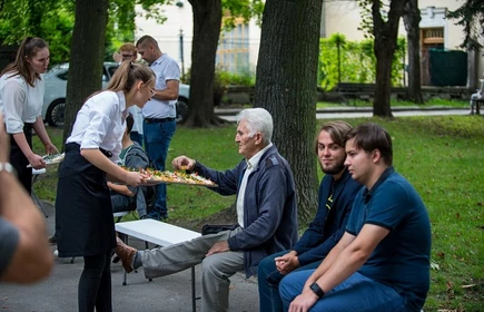Uczniowie częstujący uczestnik&oacute;w spotkania przekąskami 