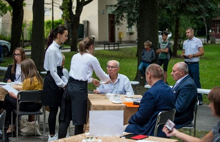 Uczniowie częstujący uczestnik&oacute;w spotkania przekąskami 