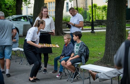 Uczniowie częstujący uczestnik&oacute;w spotkania przekąskami 