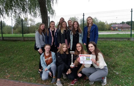 Grupowe zdjęcie zawodniczek wraz z dyplomem oraz pucharem